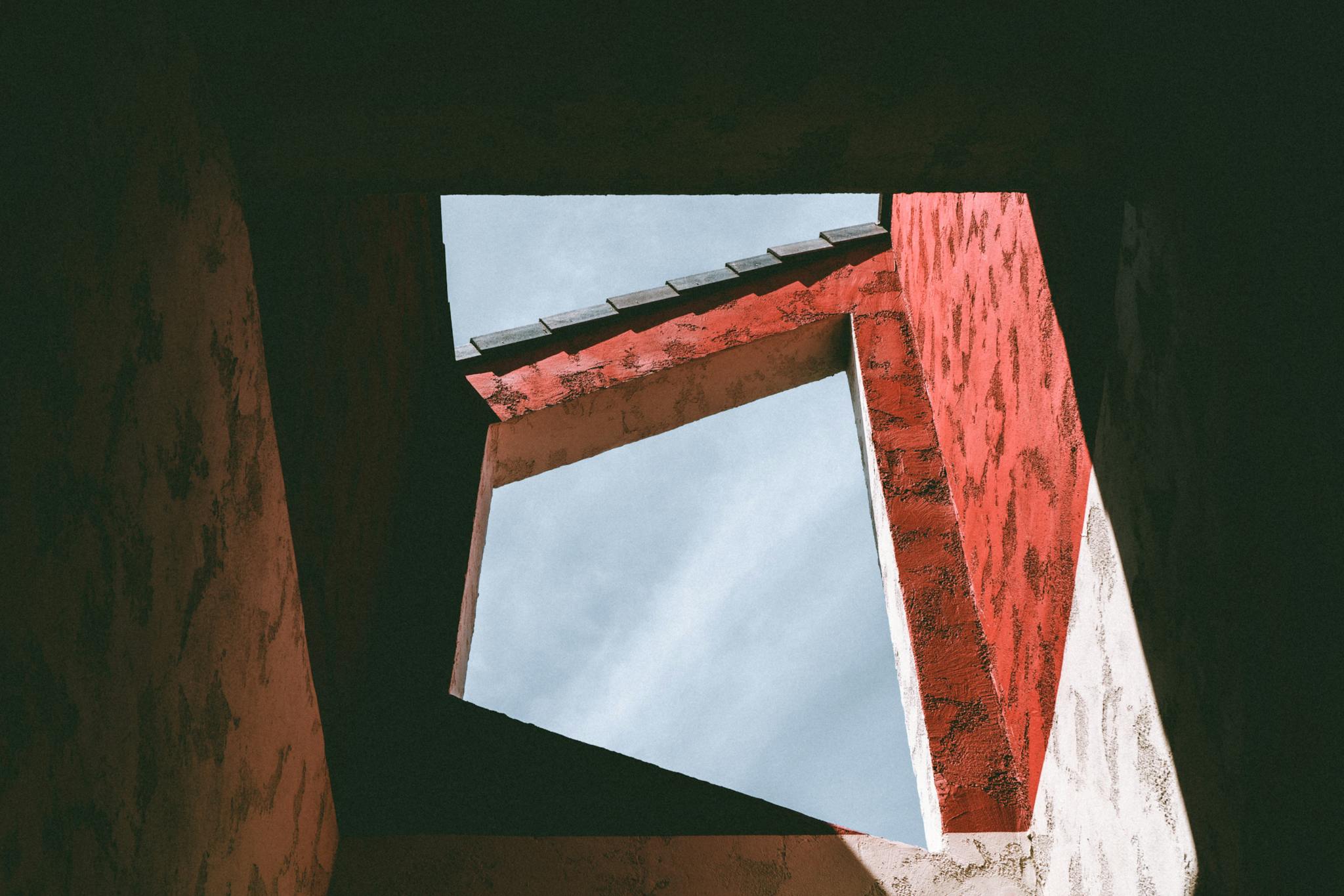 From below details of simple building with geometric shapes and windows against blue sky on sunny day